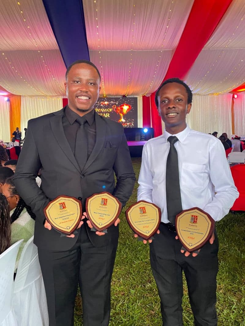 Two SCESA leaders holding the club's four award plaques at the Strathmore Clubs & Sports Gala